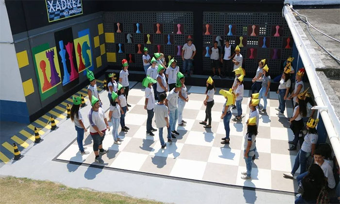 Alunos se posicionam no tabuleiro montado no pátio da escola: campeonato de xadrez criado pelo professor de matemática Marcos Araújo ajuda no desenvolvimento de aptidões utilizadas em sala de aula Foto: Divulgação/Paulo Fernando / Divulgação/Paulo Fernando